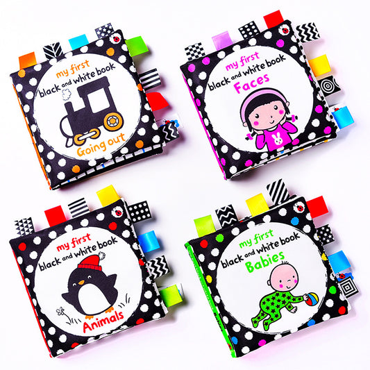 Four black and white cloth books with colorful fabric tabs and animal, face, baby and train covers